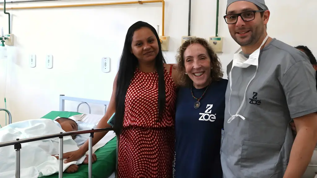 Nikita, mãe de Adriel, com voluntários da ONG Zoé ao lado do leito onde Adriel se recupera, no Hospital Municipal de Belterra