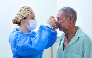 Médica realizando curativo oftalmológico em paciente