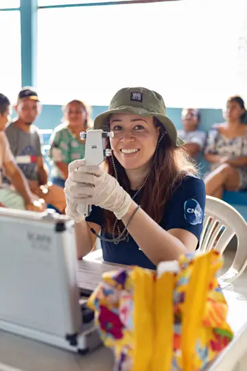 Voluntária sorrindo com equipamento oftalmológico
