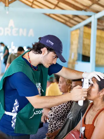 Voluntário realizando exame oftalmológico em paciente