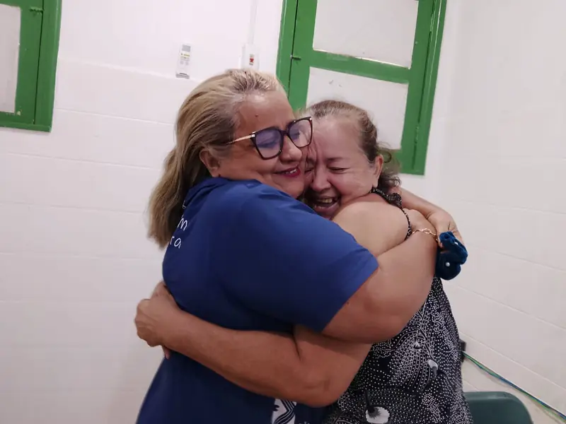 A volunteer embraces an elderly patient